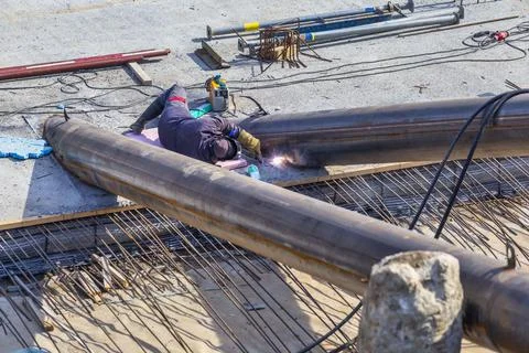 Worker welding metal pole construction Stock Photos