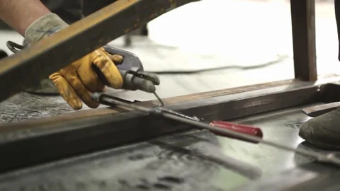 Worker welding metal with welding machine Stock Footage 128928915