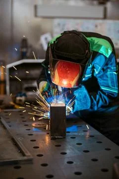 Worker welding two pieces of square tube to form a 90 degree angle - vertica Stock Photos
