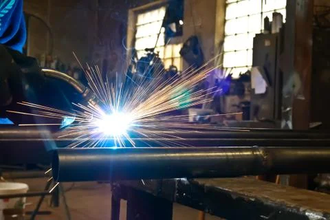 Worker Welds Iron Pipe in the Workroom. Stock Photos