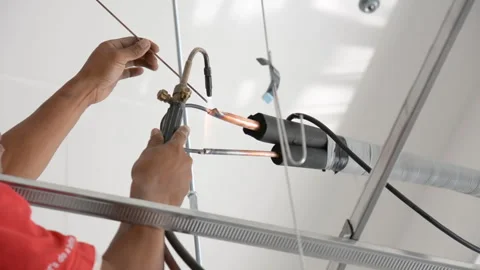 Worker welds joint of copper pipe air conditioner Stock Footage 277564874