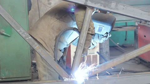 Worker welds metal structures in the factory Stock Footage 87911674