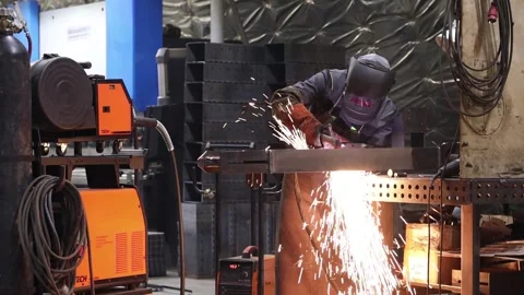 A worker welds metal structures at a factory general plan Stock-Footage 303721276