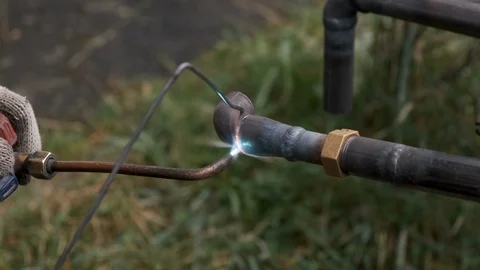 Worker welds pipe gas welding. Closeup. sparks flying around flame. fuel gase Stock Footage 117073100