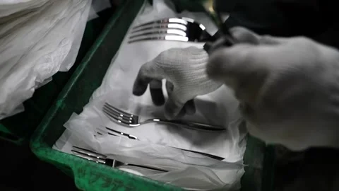 Worker in white gloves laying finished forks onto tissue paper inside green Stock Footage 340156118