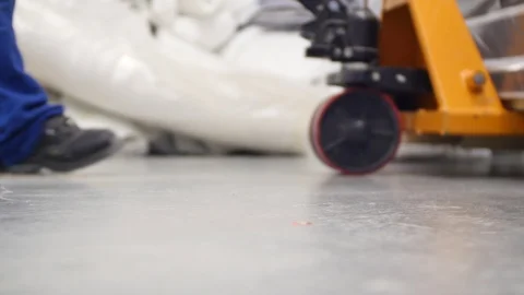 Worker who pulls a transpallet with construction materials on the concrete f Video stock 126000792