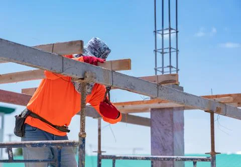 Worker wire bundle wood stick with beam scaffolding for support second floor. Stock-Fotos