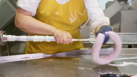 Worker woman processing packing sausage into natural casing on meat factory. 動画素材 246403858