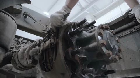 A worker in a work gloves measuring the thickness of the brake pads on a truck Stock Footage 154411001