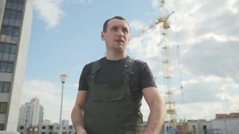 A worker work hard at construction site. Tired male builder wipes sweat from Stock Footage 141013305