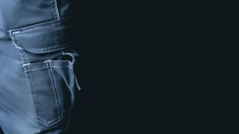 Worker in work pants. Pocket close-up on a dark background. Banner with place Stock Photos