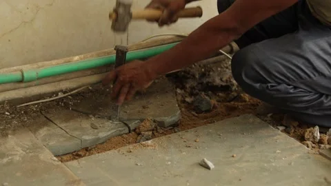 Worker working hard, removing tiles, using hammer and chisel Stock Footage 245092525