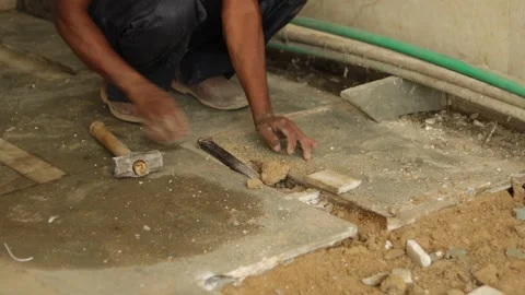 Worker working hard, removing tiles, using hammer and chisel. Stock Footage 245093946