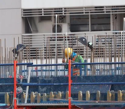 A worker is working on high contruction area, with iron wire structure Stock Photos