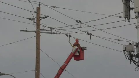 Worker working on high voltage electrical power lines in city Stockbeeldmateriaal 146106629