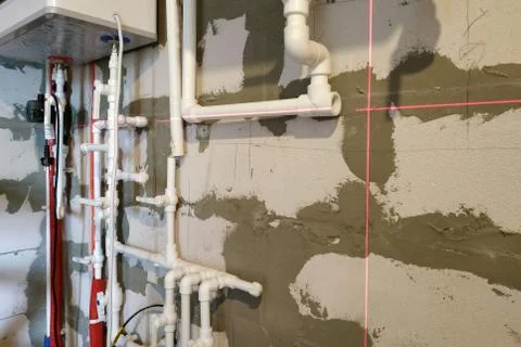 Worker is working on installing pipes for floor heating. Fotos de archivo