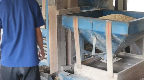Worker working on rice cleaning machine.  Stock Footage 54474056