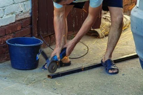 A worker works on an angle grinder. Sparks when handling metals. Metal processin Photos