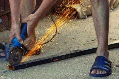 A worker works on an angle grinder. Sparks when handling metals. Metal processin Photos