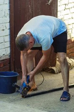 A worker works on an angle grinder. Sparks when handling metals. Metal processin Photos