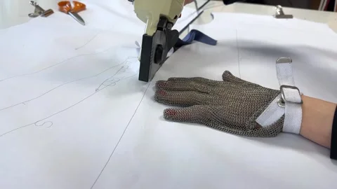 A worker works on fabric cutting machine in textile factory behind fabric Stock Footage 296074627