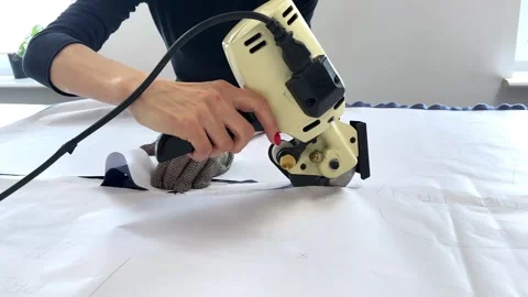 A worker works on fabric cutting machine in textile factory behind fabric Stock Footage 296074685