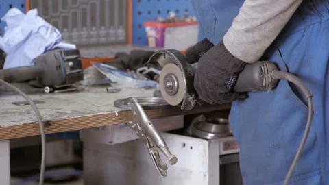 A worker works with a grinder. Hands of man cutting metal detail with grinder.  Stock Footage 139006928