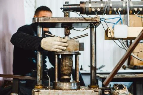 The worker works on the machine. Press for rubber penis. Stock Photos