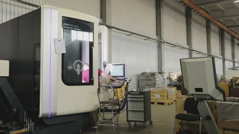 The worker works on a modern CNC machine. Modern workshop with CNC machines. A 動画素材 203882753