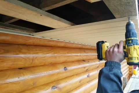 The worker works with a screwdriver, on the background of plastic and wooden  Stock-Fotos