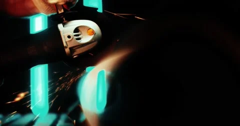 A worker in the workshop cuts a metal part with an angle grinder. Bright Video stock 167370368