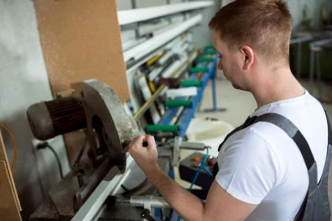 Worker in the workshop cuts pvc profile Stock Photos
