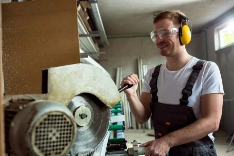Worker in the workshop cuts the pvc profile Stock Photos