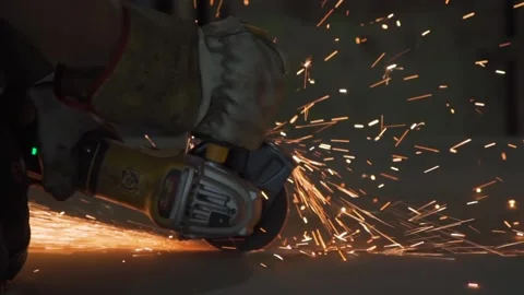 Worker in workshop cutting metal with an angle grinder, sparks flying Stock Footage 306179670