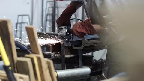 Worker in a workshop grinds metal with tool Stock Footage 81858919