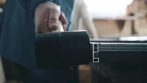 A worker in a workshop hammer in a metal profile with a rubber hammer Stock Footage 104497700