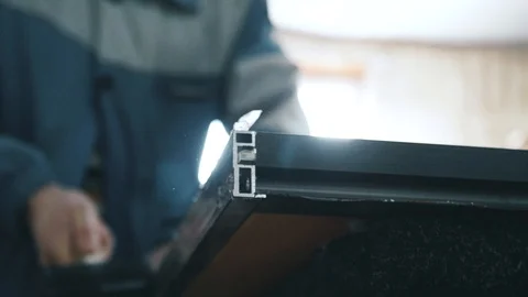 A worker in the workshop knocks on a metal profile with a rubber hammer Video stock 104497706