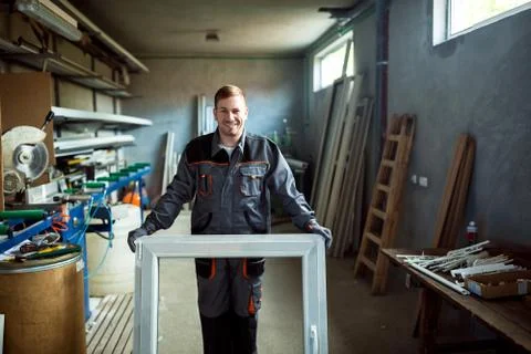 Worker in workshop for manufacture of windows and doors Stock Photos