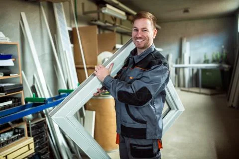 Worker in workshop for manufacture of windows and doors Stock Photos