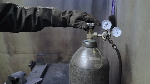 A worker in the workshop opens the valve of the oxygen or gas tank. Stock Footage 152511235
