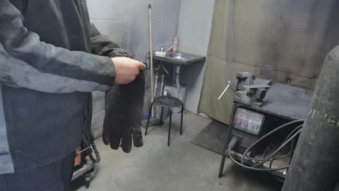 A worker in a workshop puts on protective gloves on his hands Stock Footage 152511357