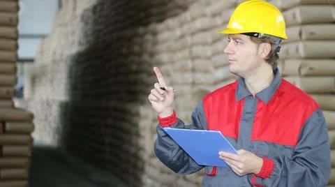 Worker writing on clipboard in Warehouse Stock Footage 12418338