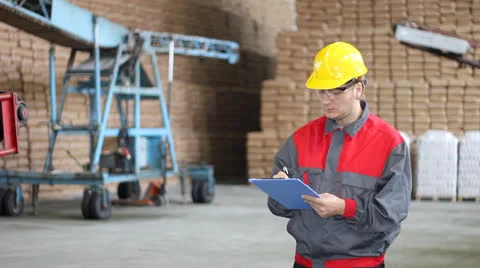 Worker writing on clipboard in Warehouse Stock Footage 27166997