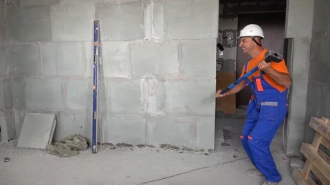 Worker young man with a sledgehammer in his hand dancing and dancing, the end of Stock Footage 115438204