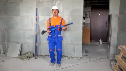 Worker young man with a sledgehammer in his hand dancing and dancing, the end of Stock Footage 115438221