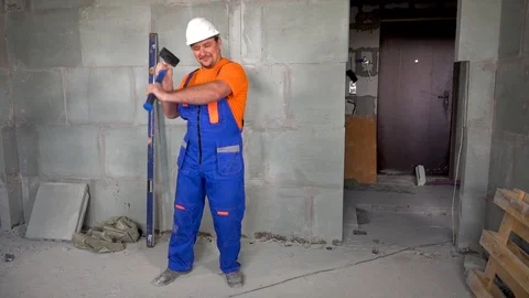 Worker young man with a sledgehammer in his hand dancing and dancing, the end of Stock Footage 115438294