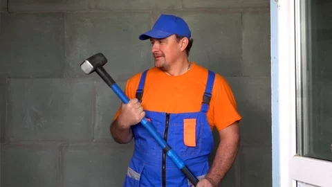 Worker young man with a sledgehammer in his hand dancing and dancing, the end of Stock Footage 115439632