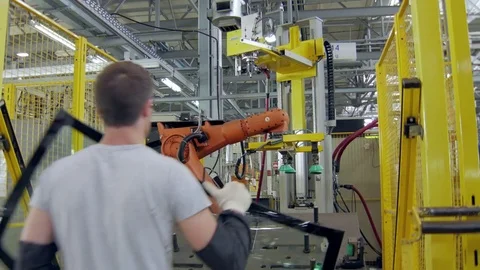 Workerman is installing a car windows on a platform of robotic machinery for Stockbeeldmateriaal 83430925