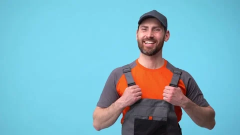 Workerman in uniform laughs at the situation and takes his head in surprise Stock Footage 188096369