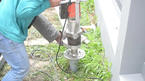 Workerr twists the screw piles foundation for building home Stock Footage 162057237